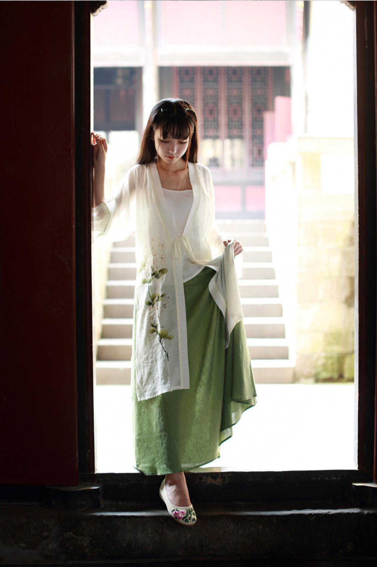 半藏森林穿着白色对襟褙子长款上衣正提着衣角跨过门槛
