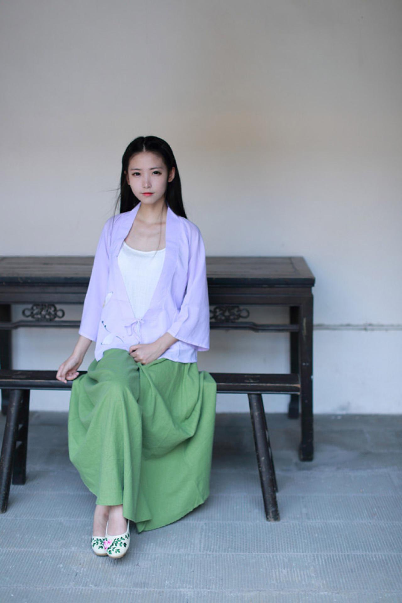 半藏森林穿着紫色对襟褙子长款上衣坐在长椅上