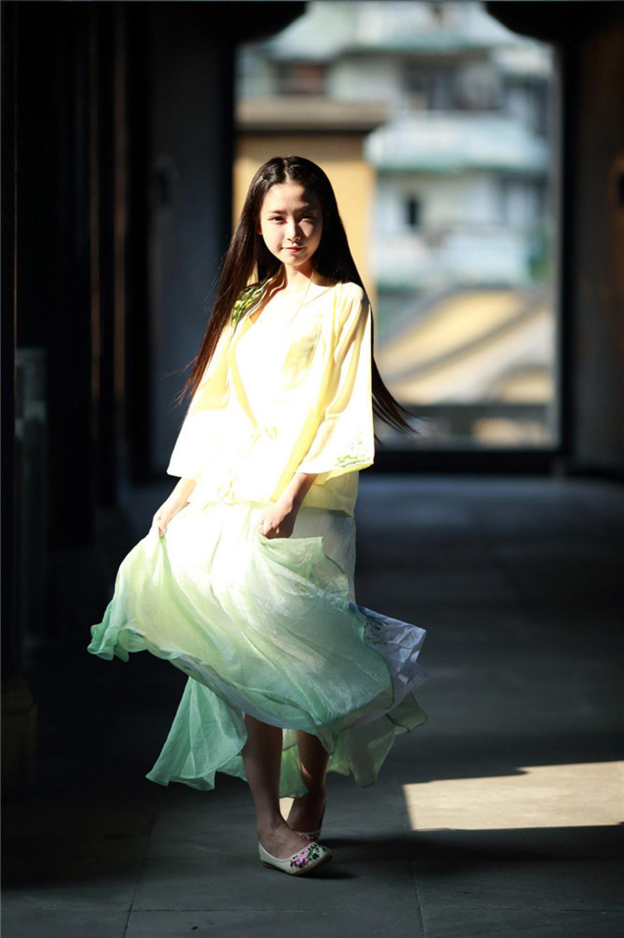 半藏森林穿着黄色对襟长袖雪纺上衣站在石路上