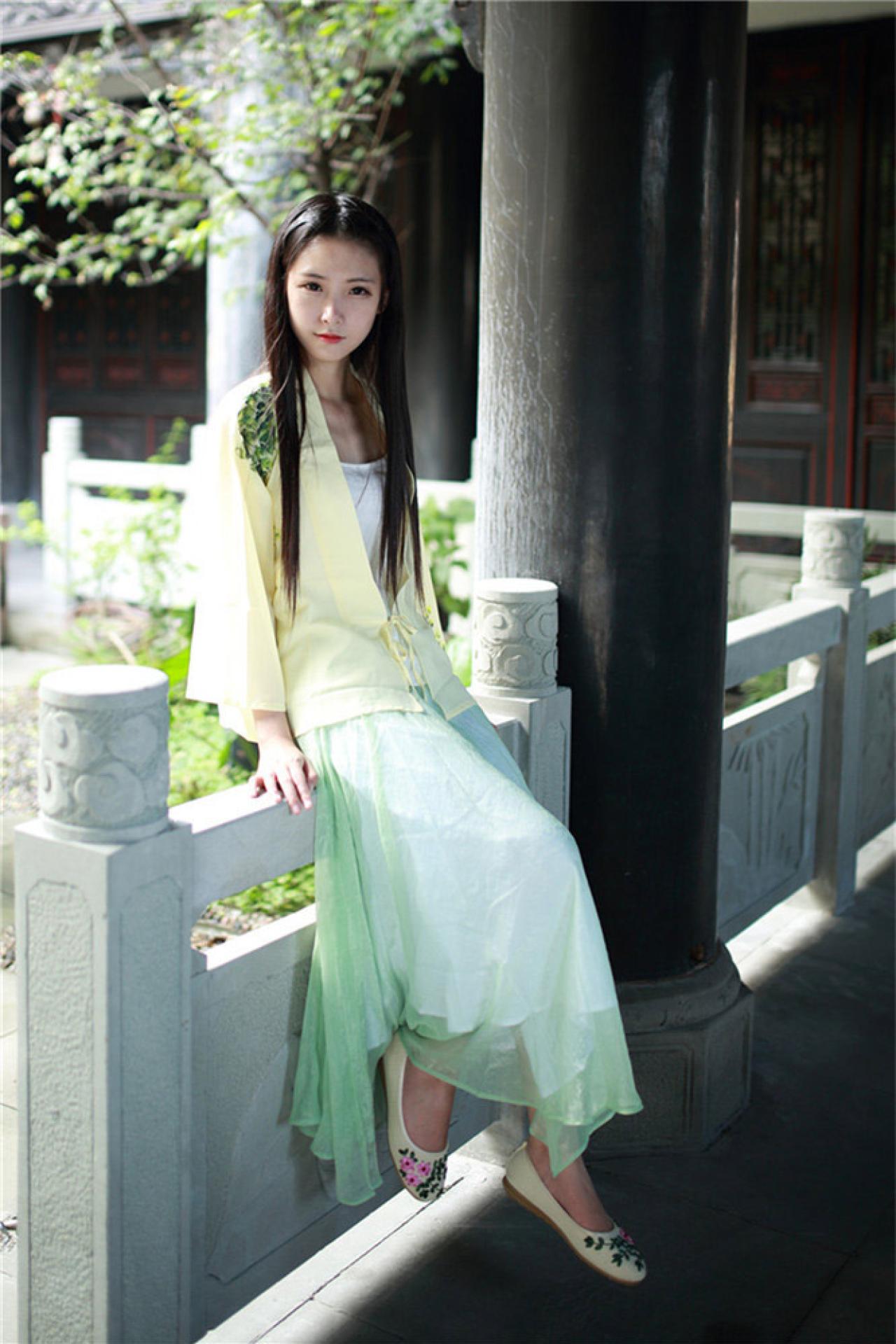 半藏森林穿着黄色对襟长袖雪纺上衣坐在亭子旁的栏杆上