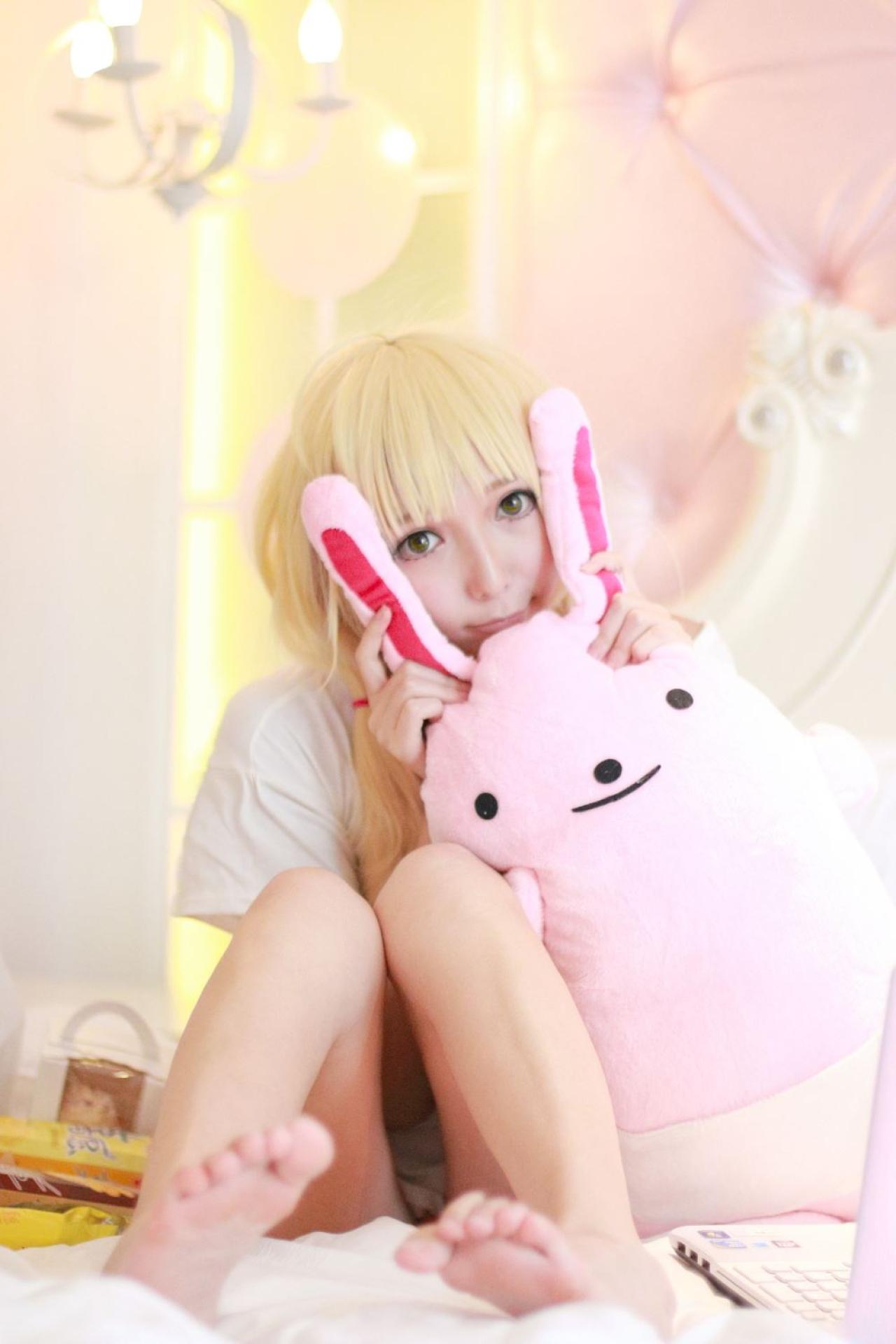 茶茶茶茶喵扮演双叶杏揪着粉色玩偶的兔耳朵，把脸藏在兔耳朵之间