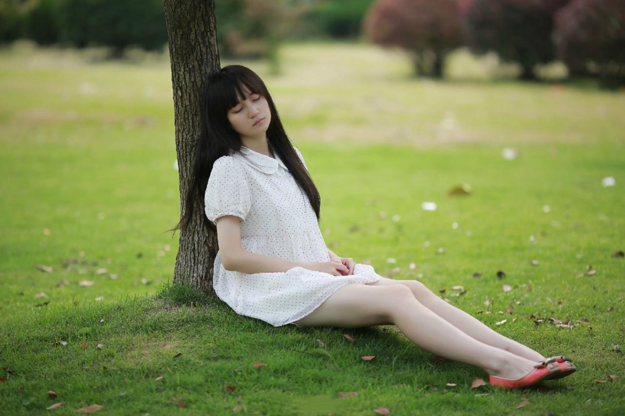 苏里柟穿着白色波点罩衫躺在树干上睡着的样子