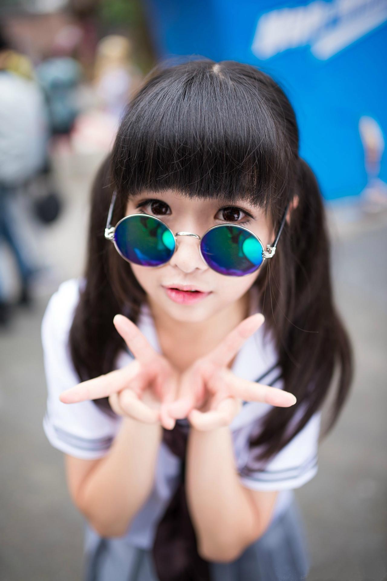 草纸戴着眼镜双手作剪刀手势卖萌的姿势