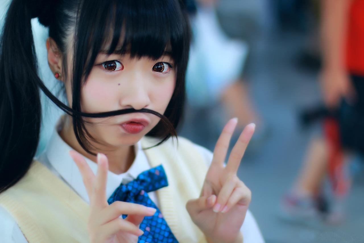 鳄鱼同学鼻子上吸着一缕发丝，双手做兔耳朵状，嘟嘴卖萌的姿势