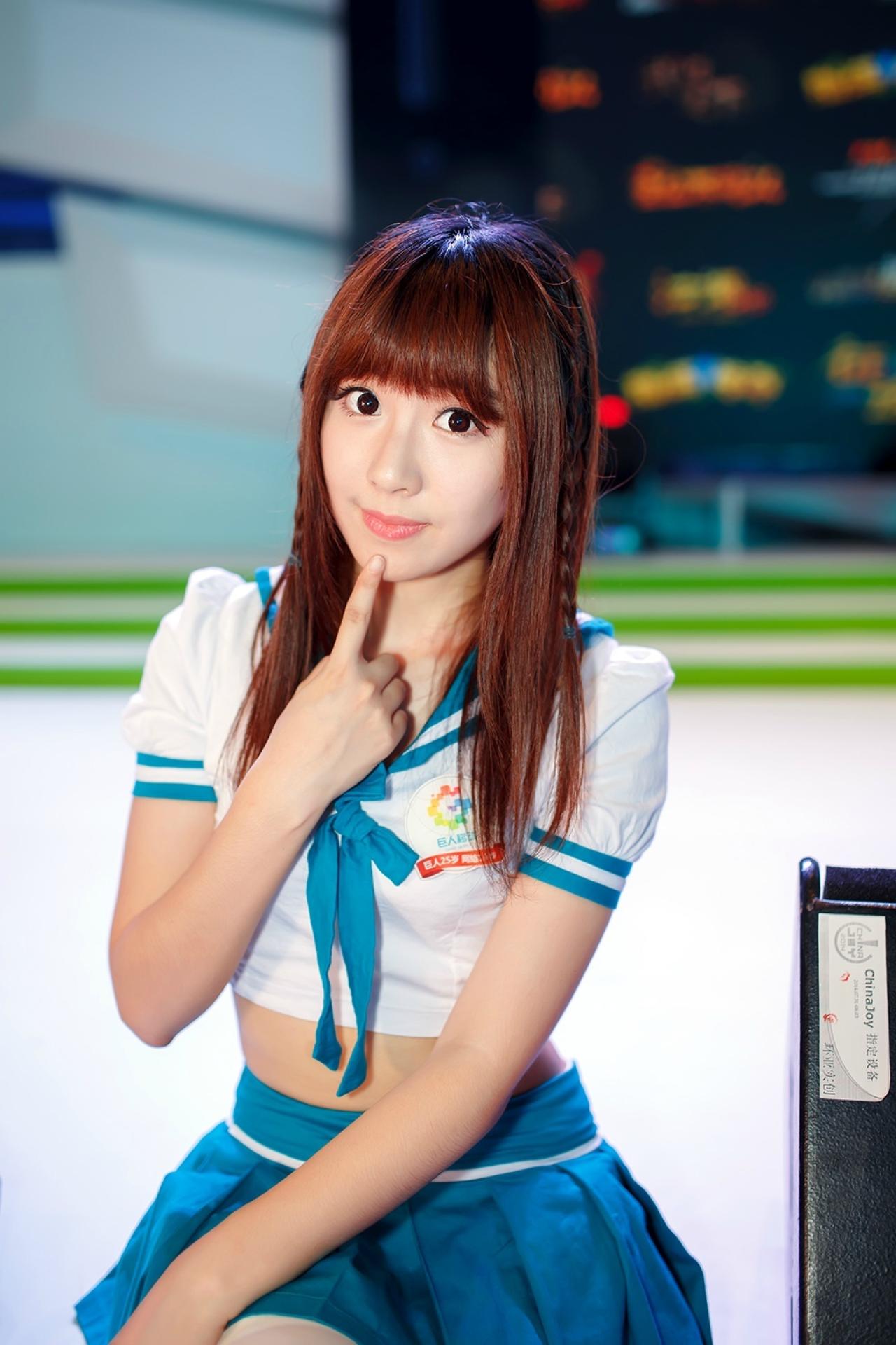 穿着蓝白水手服的巨人移动Showgirl坐在展台手指抵住下巴卖萌的姿势