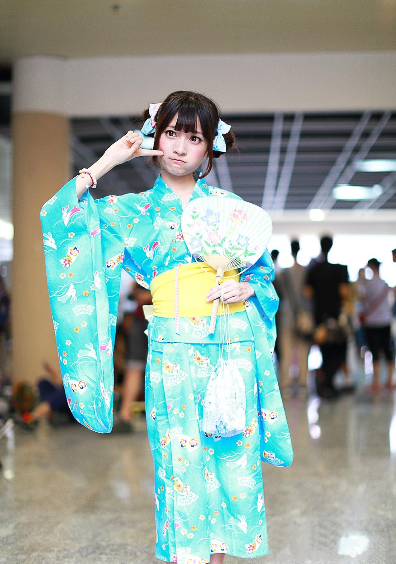 橘子酱左手持扇，右手食指按住脸，嘟嘴卖萌 孤岛桑-MccVision拍摄