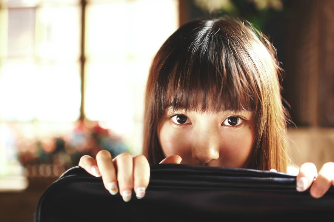 山田実瑠用黑色皮包遮住自己半边脸