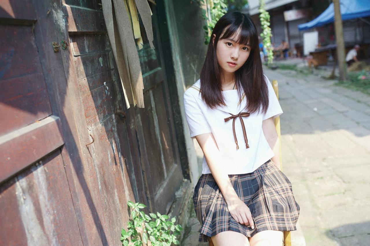 山田実瑠坐在老宅门前的躺椅上，歪着头看镜头