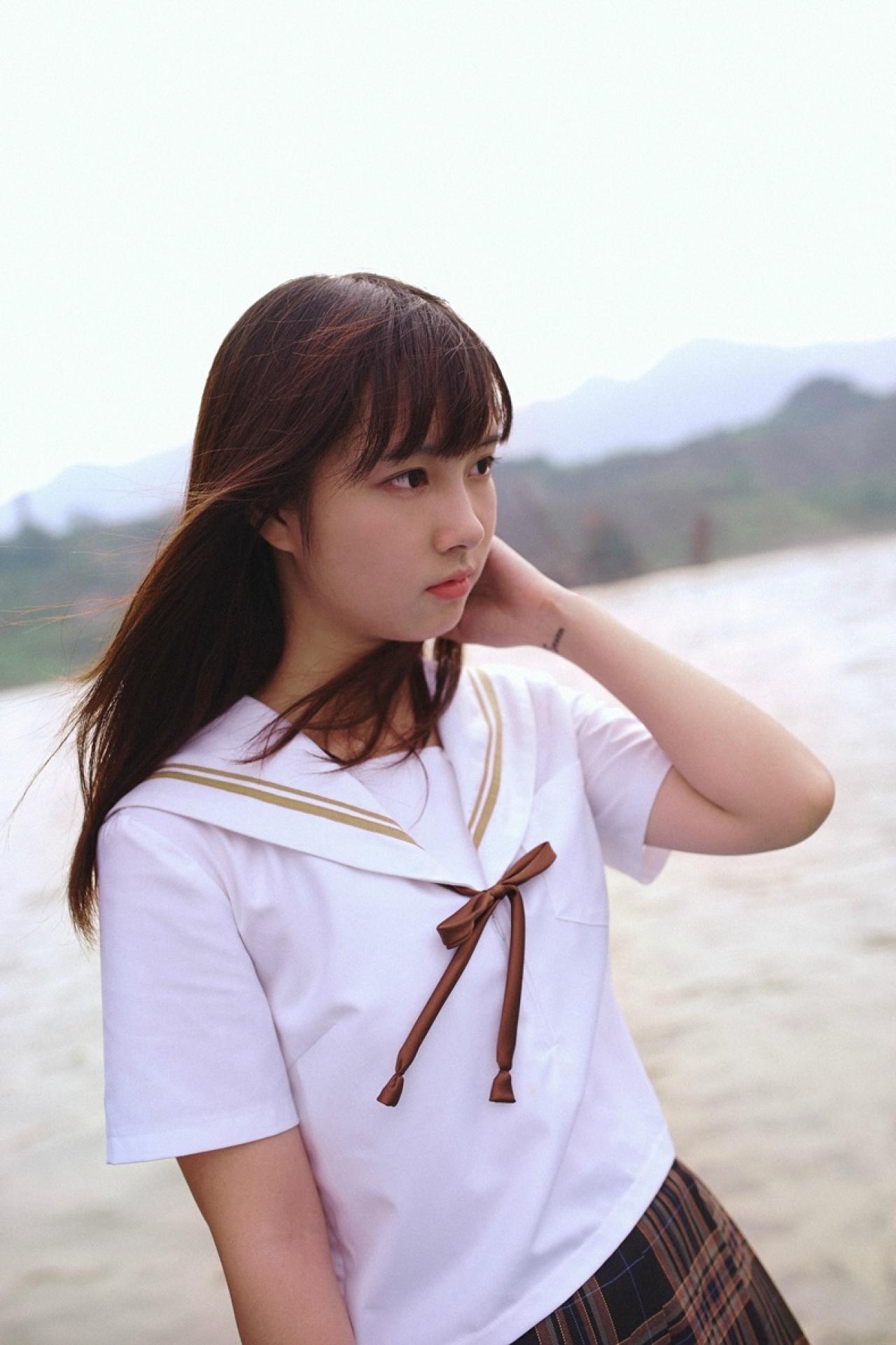 山田実瑠站在海边，屏风而立，轻抚头发眺望远方