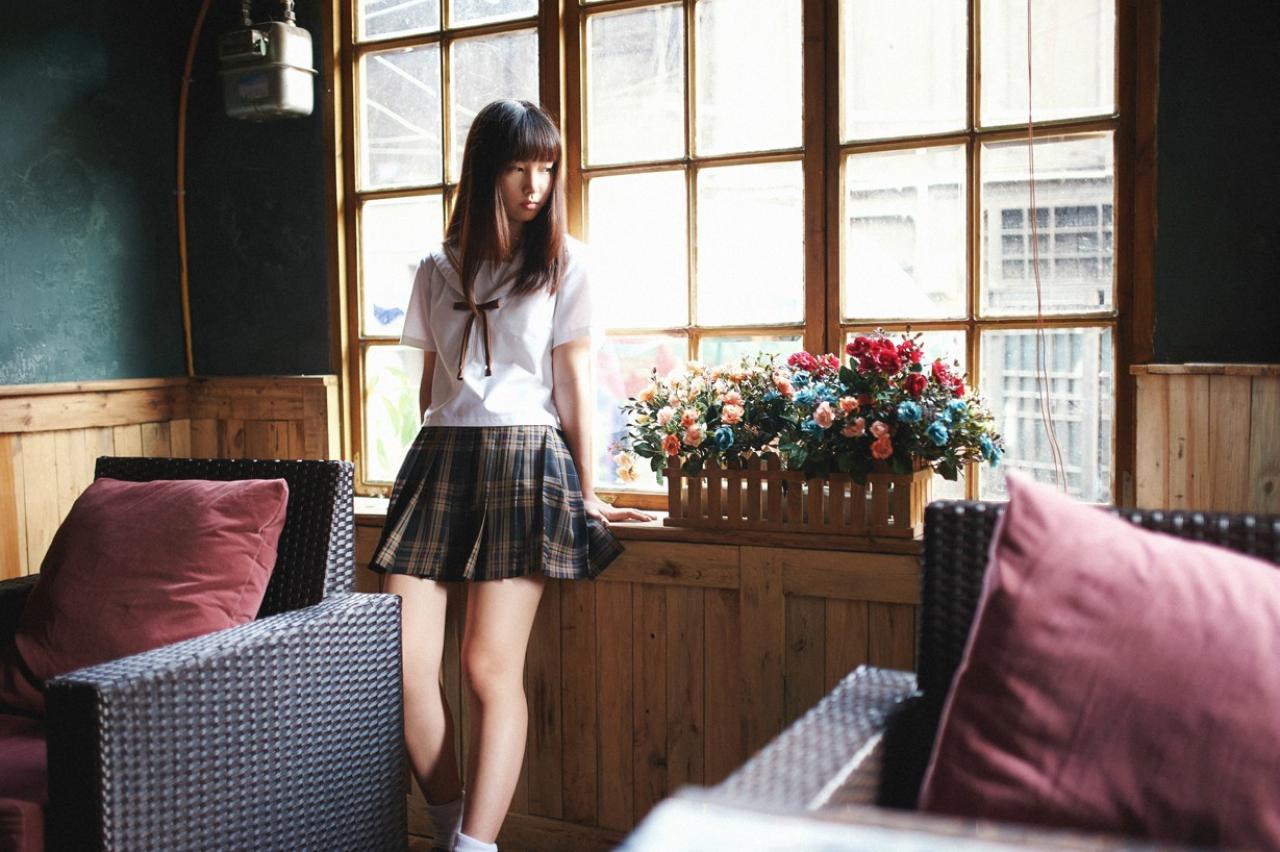 山田実瑠背靠在窗前，转头看着花篮里的花