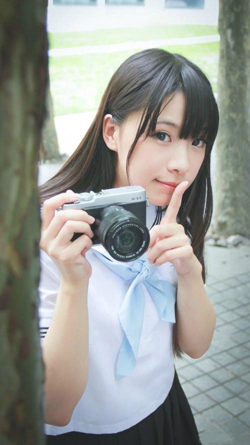 贤儿sherry右手拿着相机，左手作嘘的手势