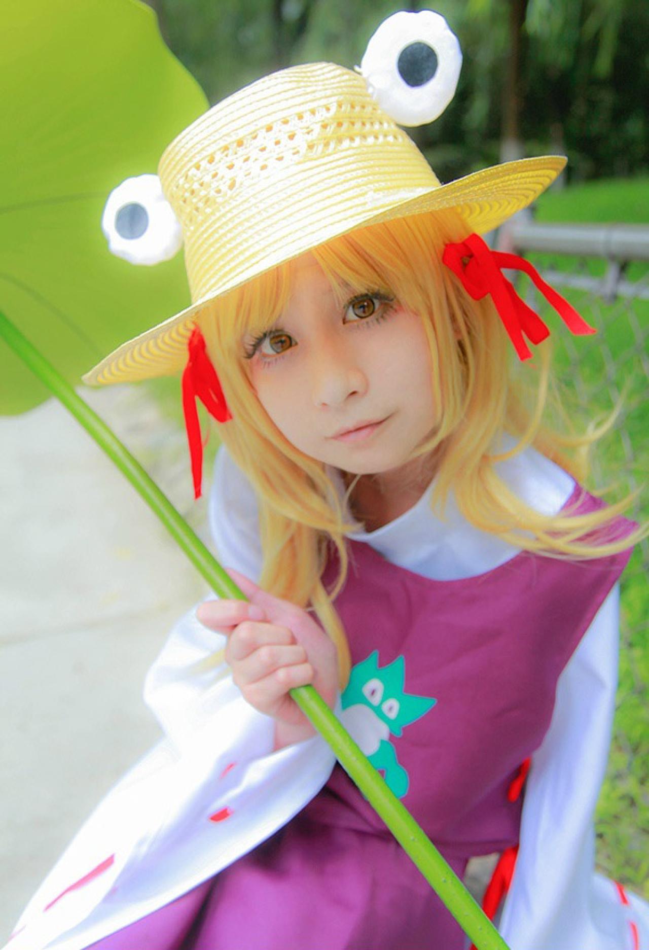 桃小陌扮演泄矢诹访子双手拿着荷叶茎秆，歪着头看镜头正面照