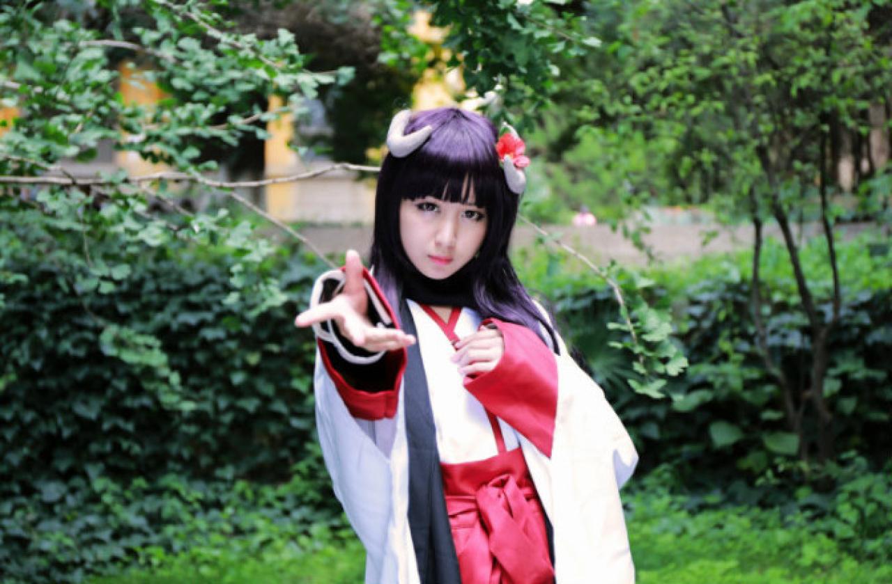 小雫扮演白鬼院凛凛蝶伸出右手，左手放在胸前的姿势