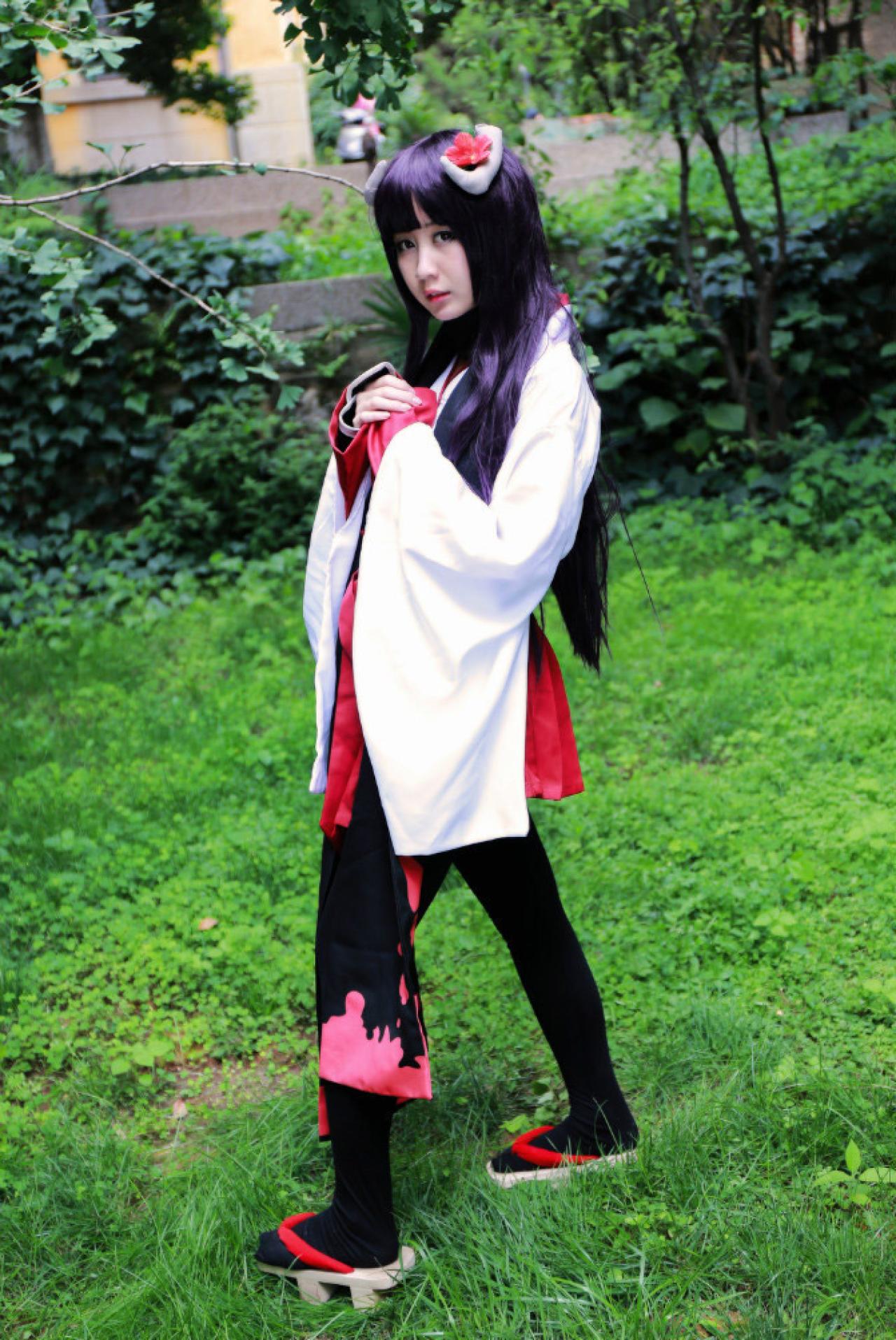 小雫扮演白鬼院凛凛蝶双手放在胸前叉开腿站立的侧面照