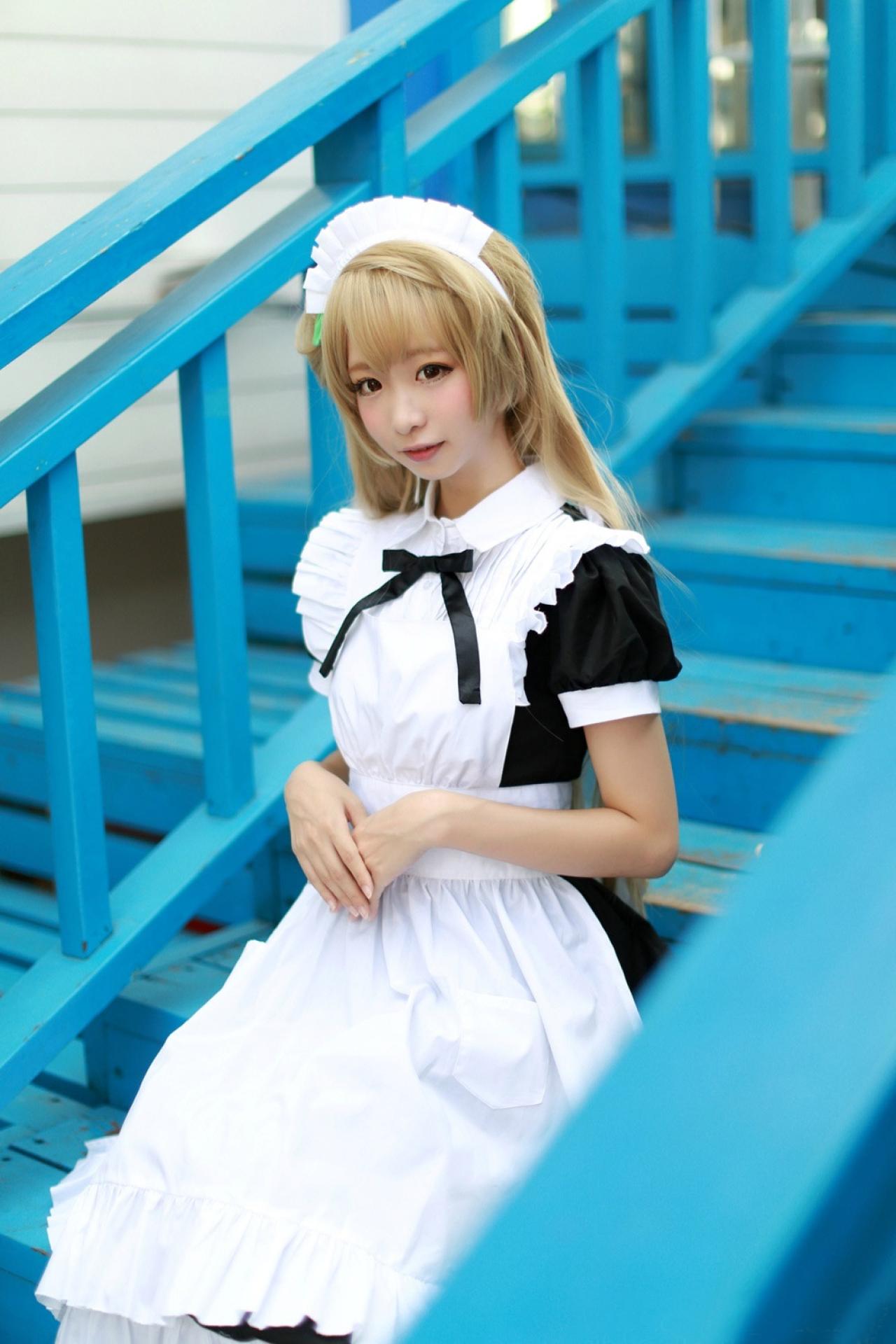 鳄鱼同学扮演南小鸟端坐在蓝色楼梯的台阶上