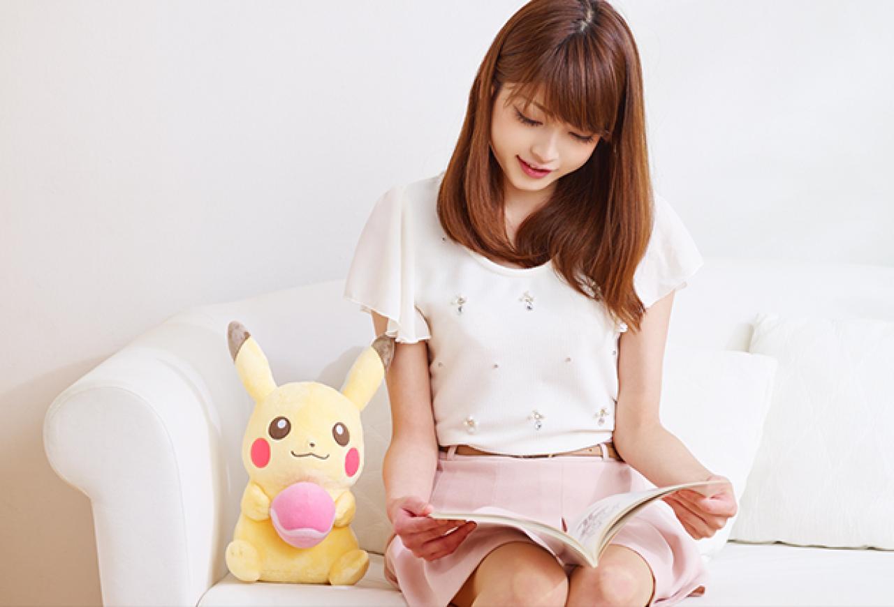 萌妹子和皮卡丘玩偶一起在沙发上看书
