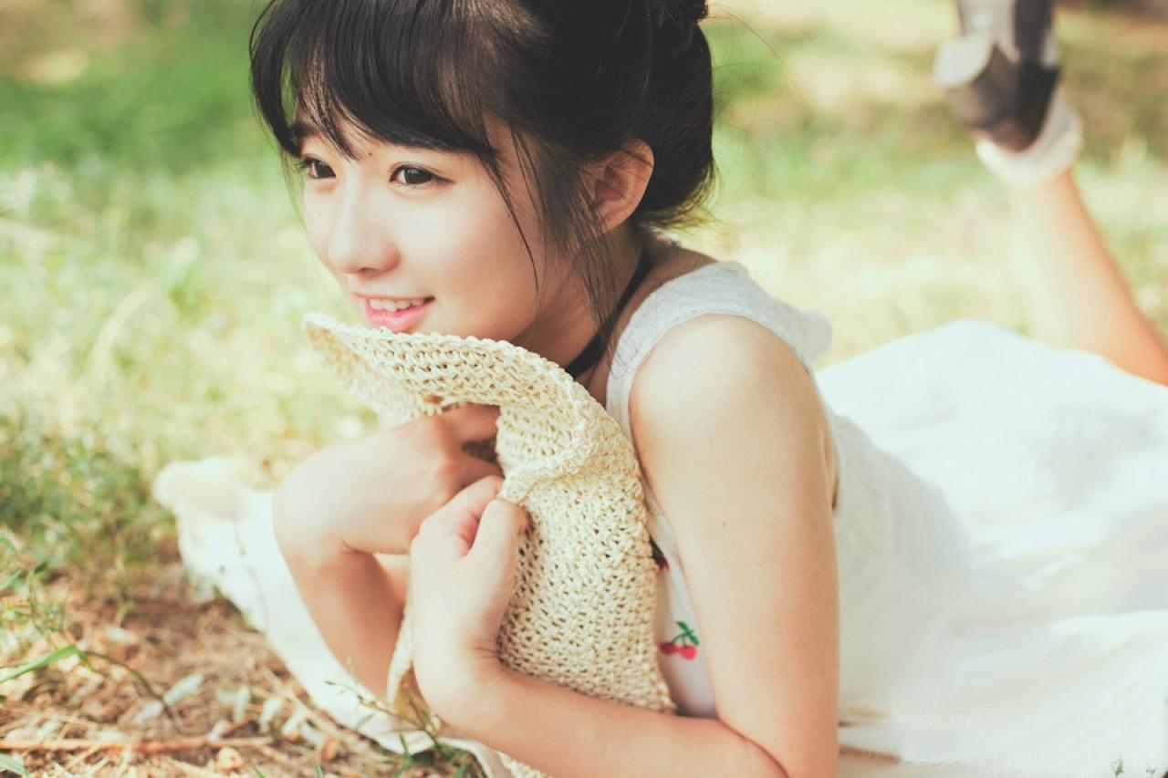 小陆离抱着草帽扒在草地上 全身照