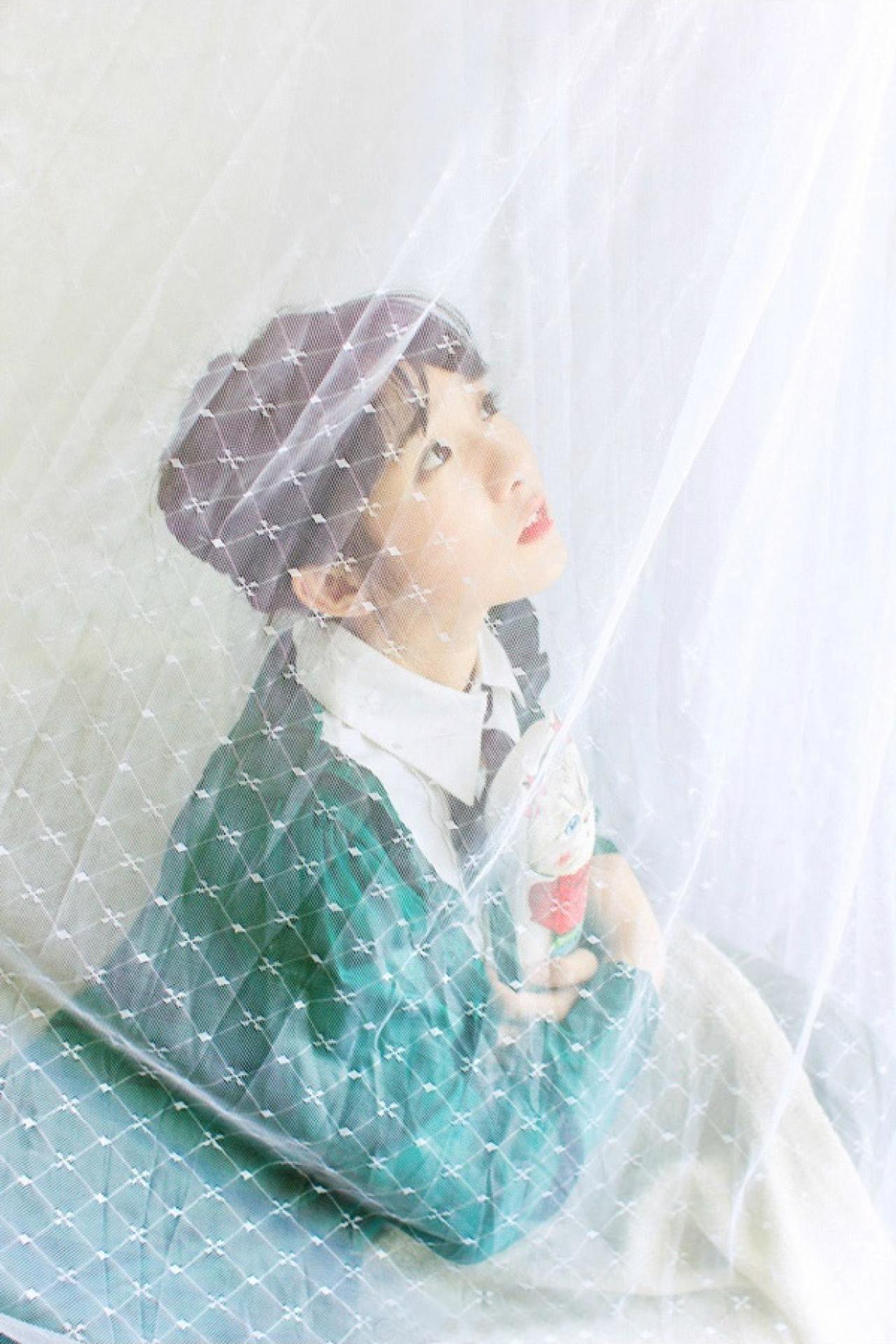 小陆离在薄纱中，抱着玩偶，45度角仰望天空