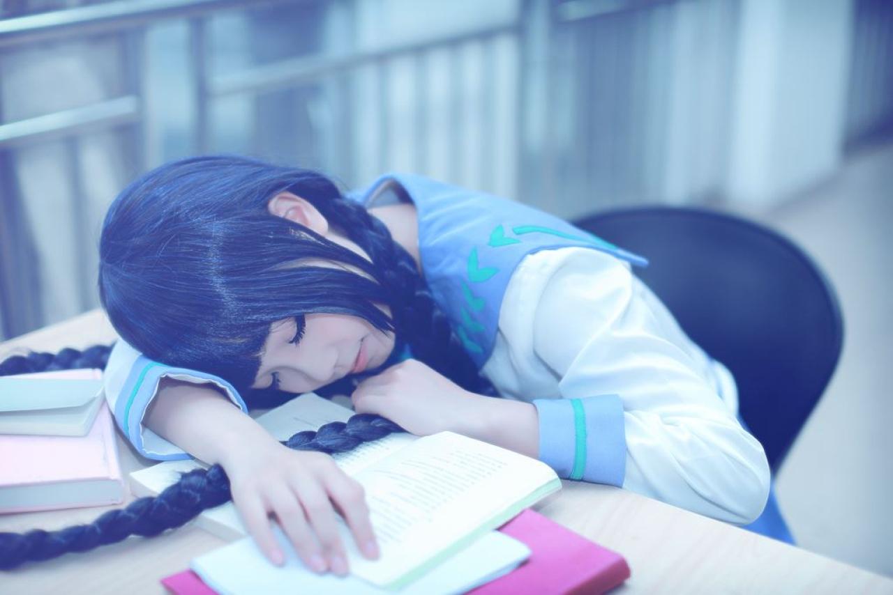 帕琪与兔扮演天野远子坐在椅子上，右手抚摸着书，左手抓着马尾辫，扒在胳臂上睡着了