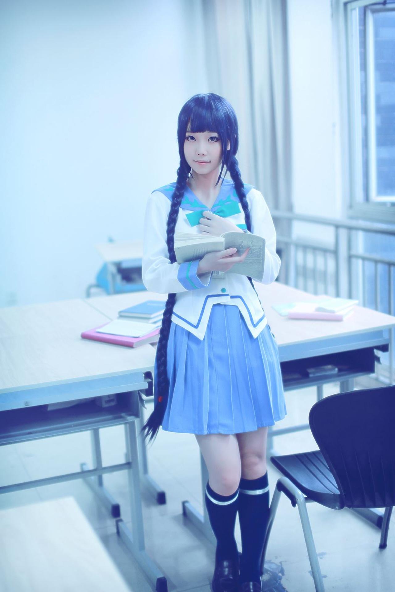 帕琪与兔扮演天野远子站着靠在桌子上，右手放在胸前，左手端着书本的全身照
