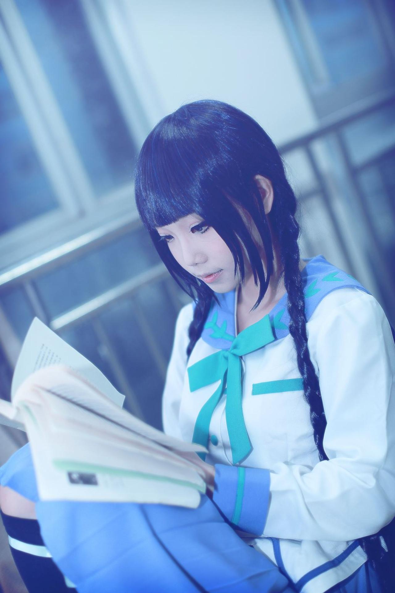 帕琪与兔扮演天野远子靠在椅子上，把书放在膝盖上，低头翻阅的情景