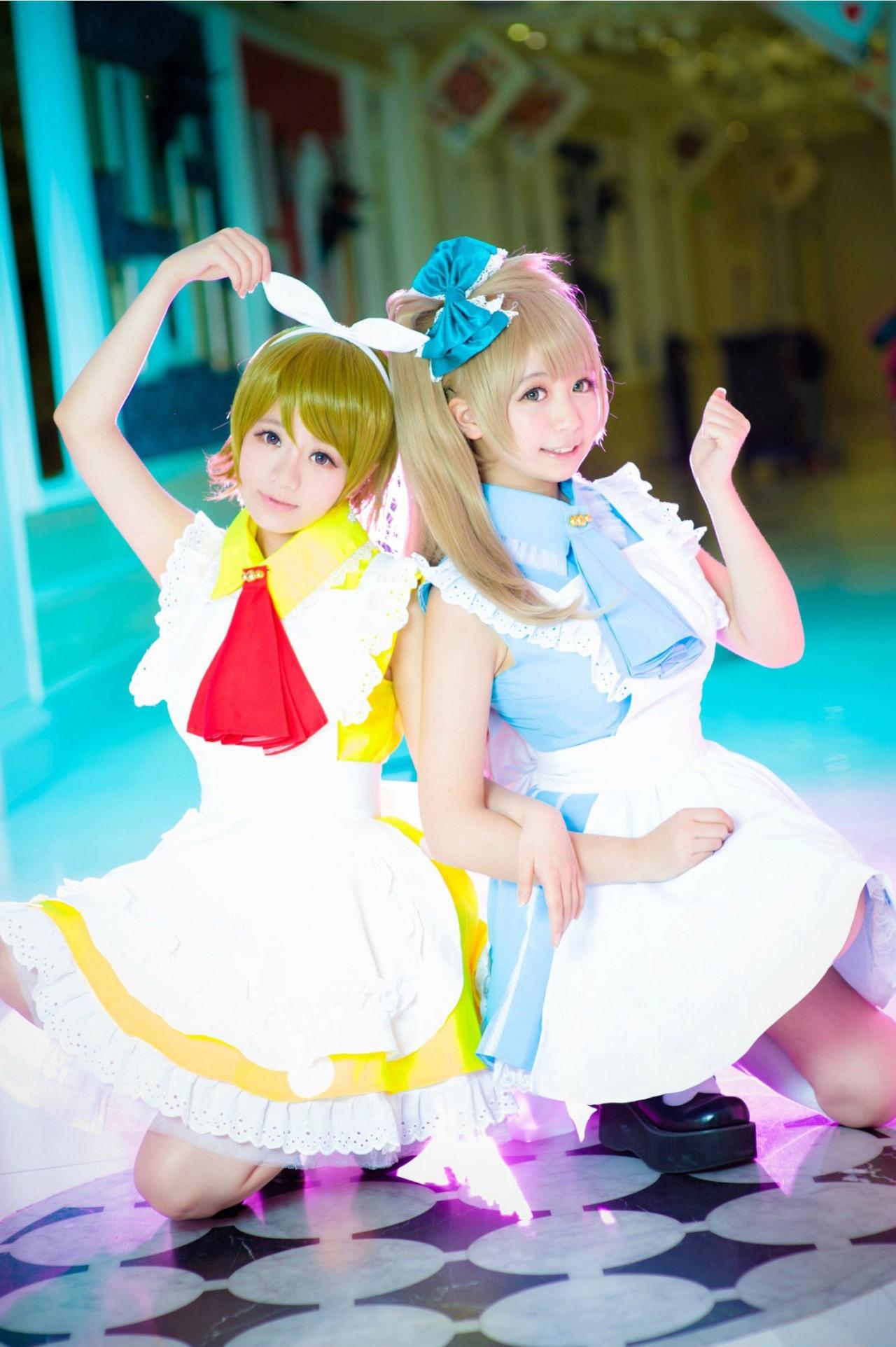 亚米_yami扮演的南小鸟和宝bA0_扮演小泉花阳手挽手，南小鸟作半握拳举起左手，小泉花样举起右胳膊作半个心形手势