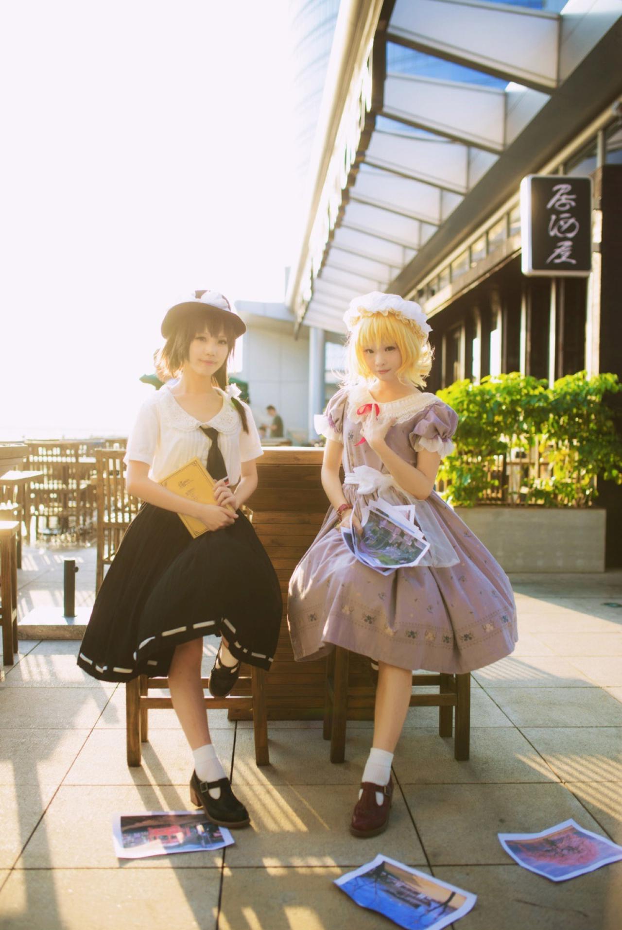 莲子抱着书，梅莉拿着图纸，两人坐在椅子上