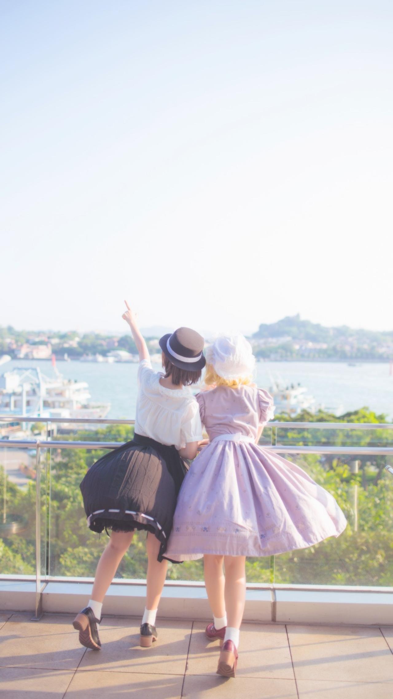 莲子和梅莉扒在栏杆，遥望码头，莲子指着天空，梅莉顺着莲子所指看去