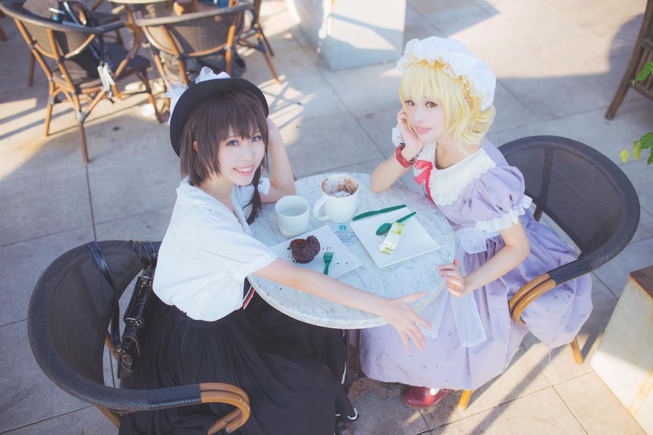 梅莉和莲子一起撑着桌子冲着镜头微笑