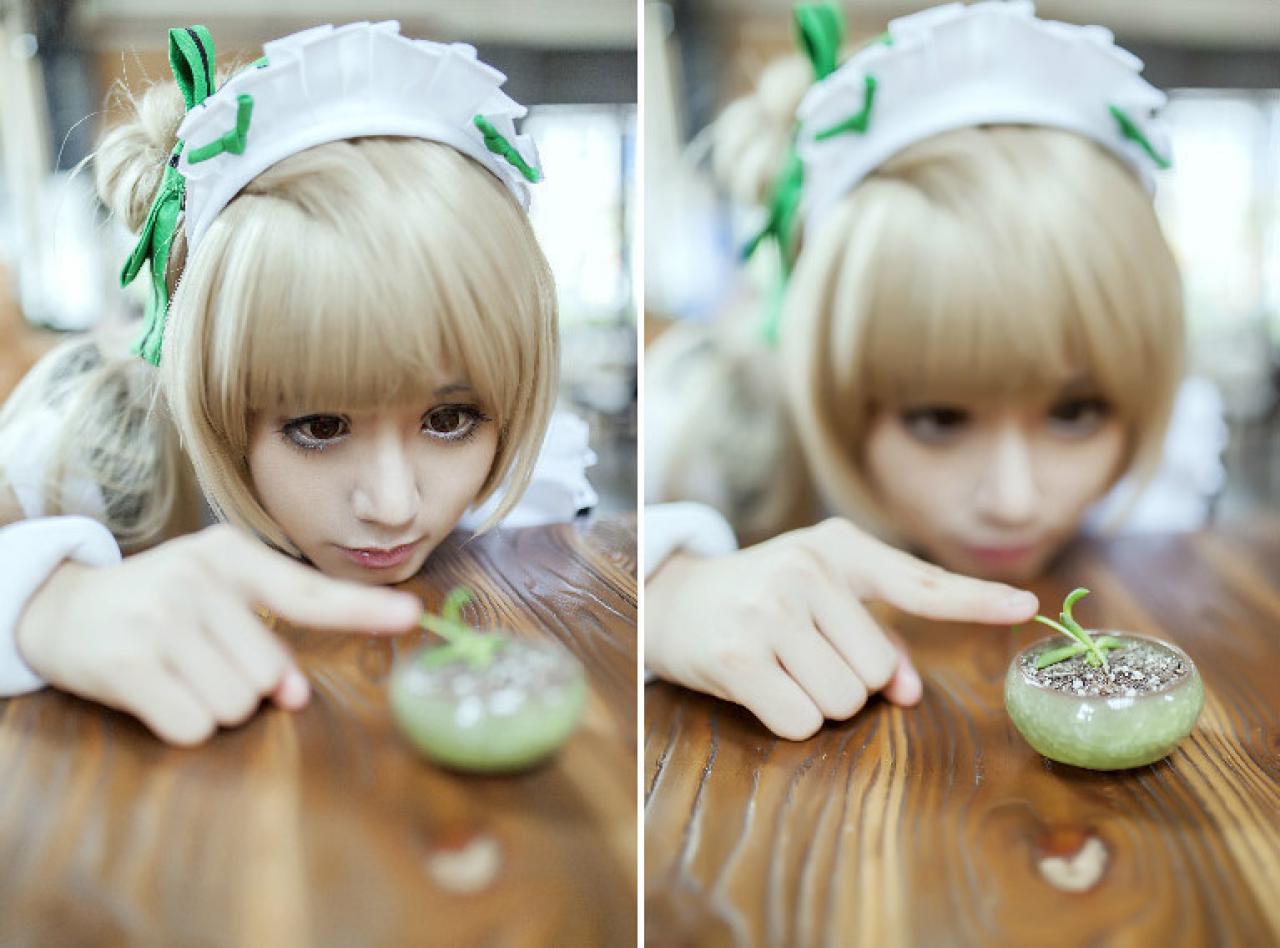 冰夜酱扮演南小鸟头扒在桌子上，出神地轻轻的用右手食指抚摸一颗嫩苗