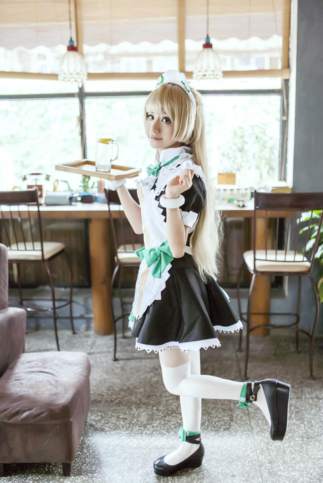 冰夜酱扮演南小鸟右手撑着盘子，左手半握拳，向后抬起左脚，卖萌姿势的侧面照