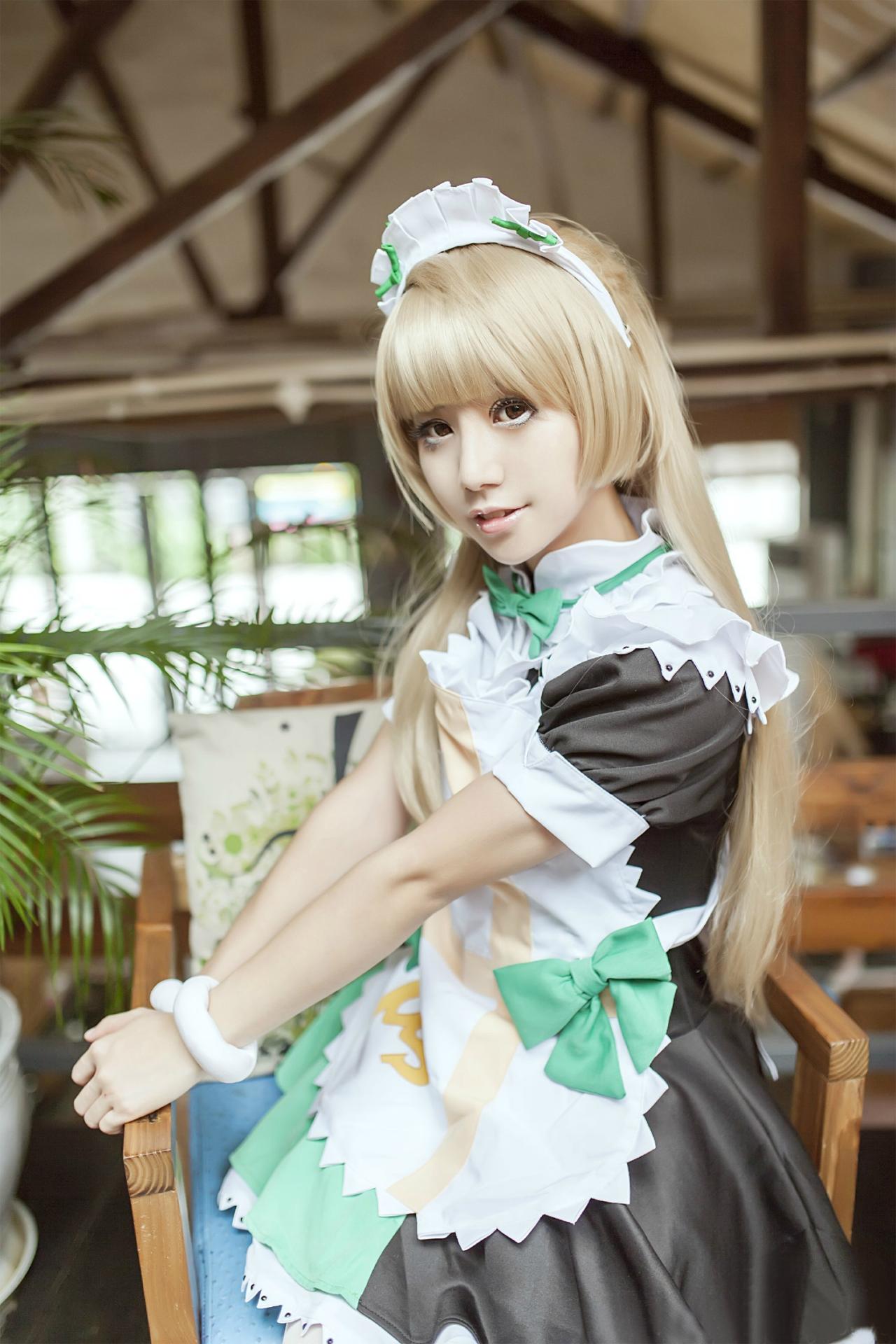 冰夜酱扮演南小鸟双手撑在椅子扶手上，跪坐在椅子上面