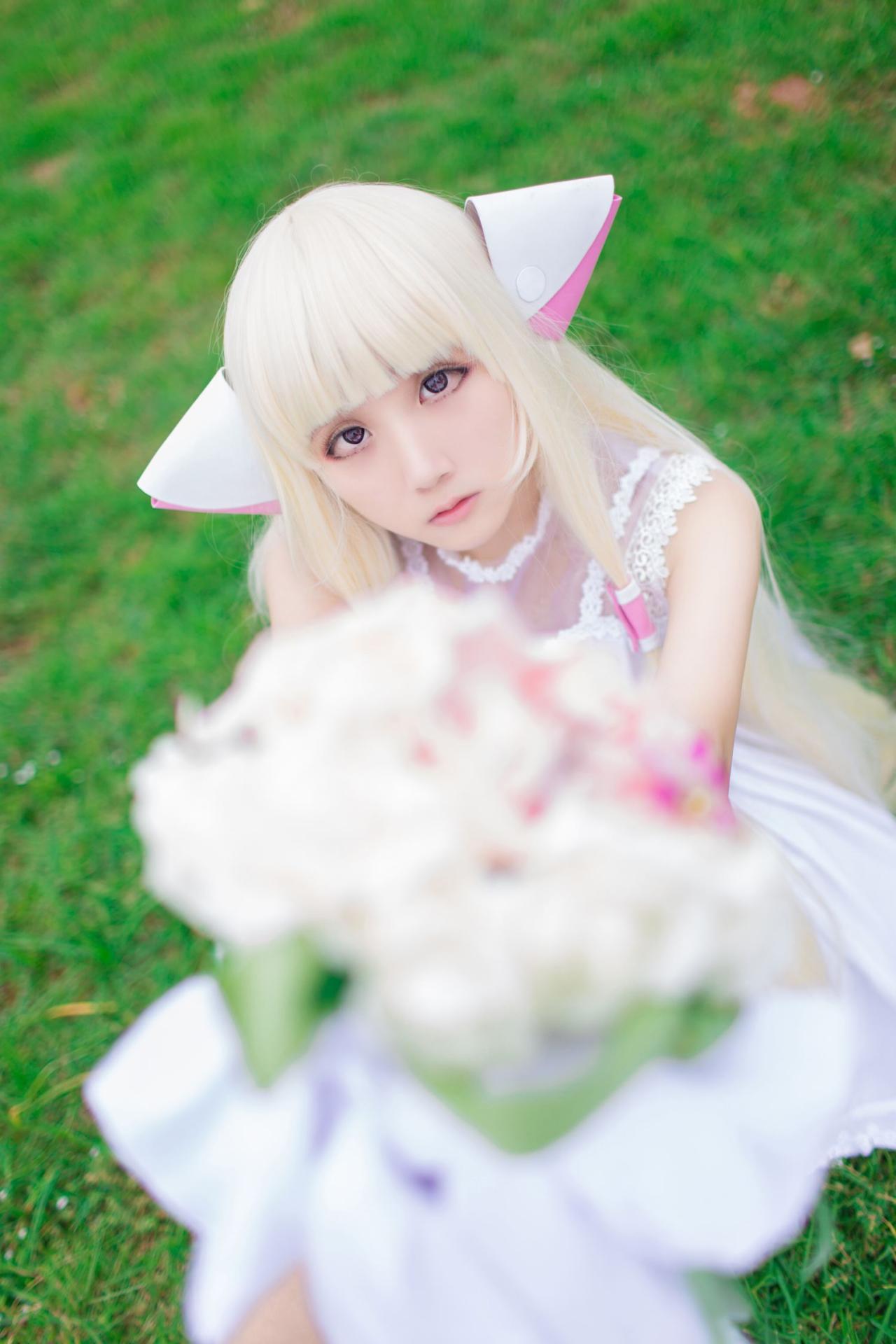 菌子扮演小叽坐在草地上举起手捧花