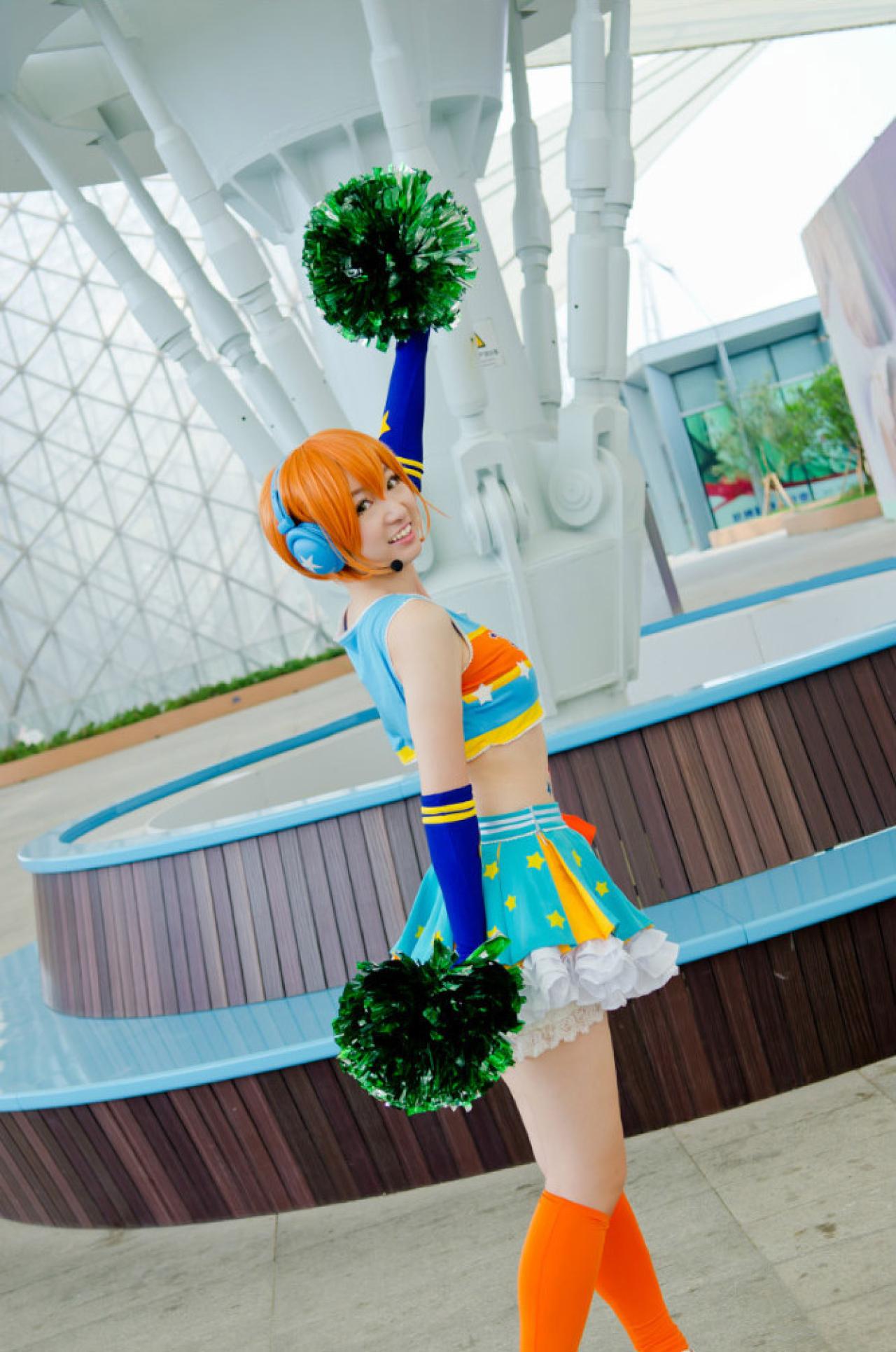 superpopopo扮演星空凛左手举起花球，右手自然下垂，扭过头微笑的侧面照