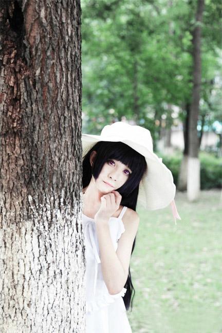 桃小陌扮演黑猫躲在粗粗的树干背后，露出半边身子，左手扶着下巴