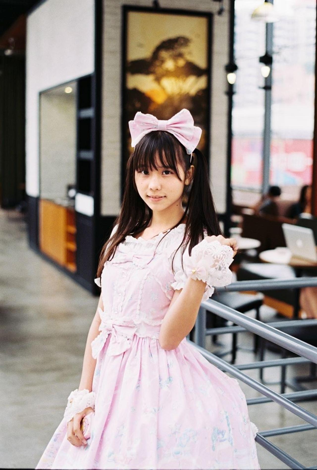 茶子在咖啡厅的入口，右手放在腰部，左手梳理头发