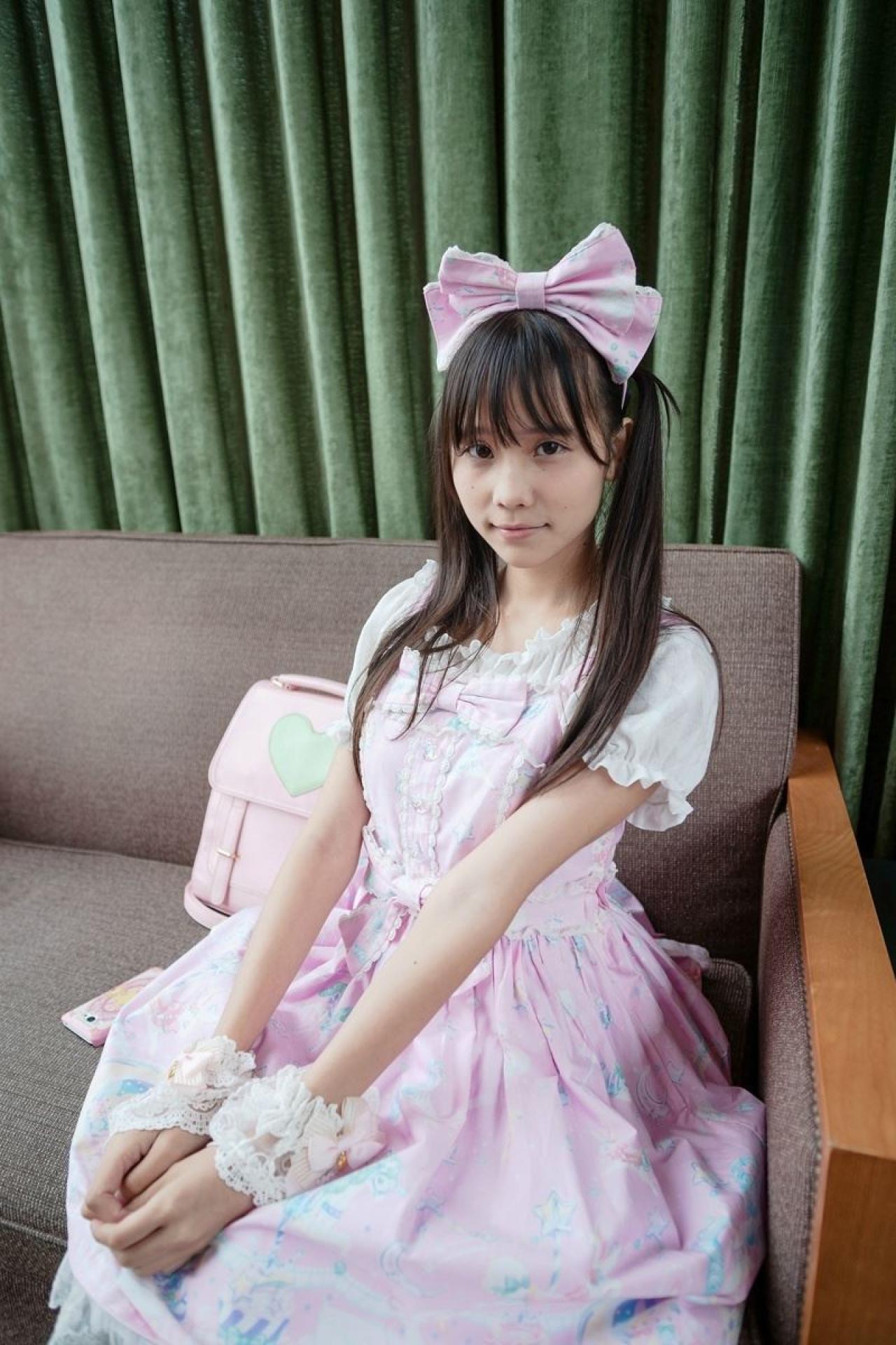 茶子端坐在沙发上，身旁放在粉色手机和背包