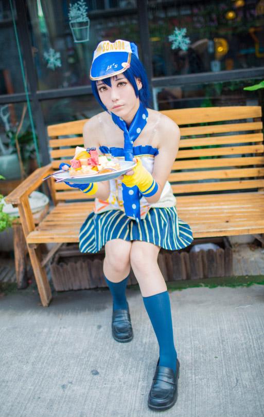 木年年扮演园田海未坐在长椅上捧着一盘食物