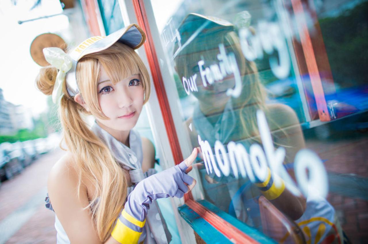 黑川扮演南小鸟靠在宣传牌，用手指着上面的文字