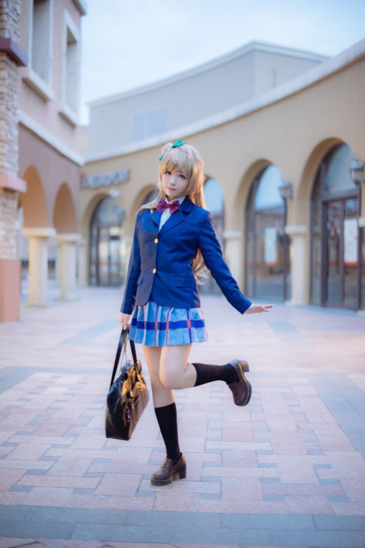 四月www扮演南小鸟提包站在林立的西洋风格建筑中