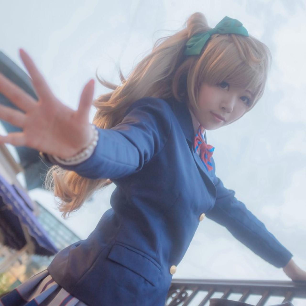 四月www扮演南小鸟左手扶着栏杆，右手五指伸开