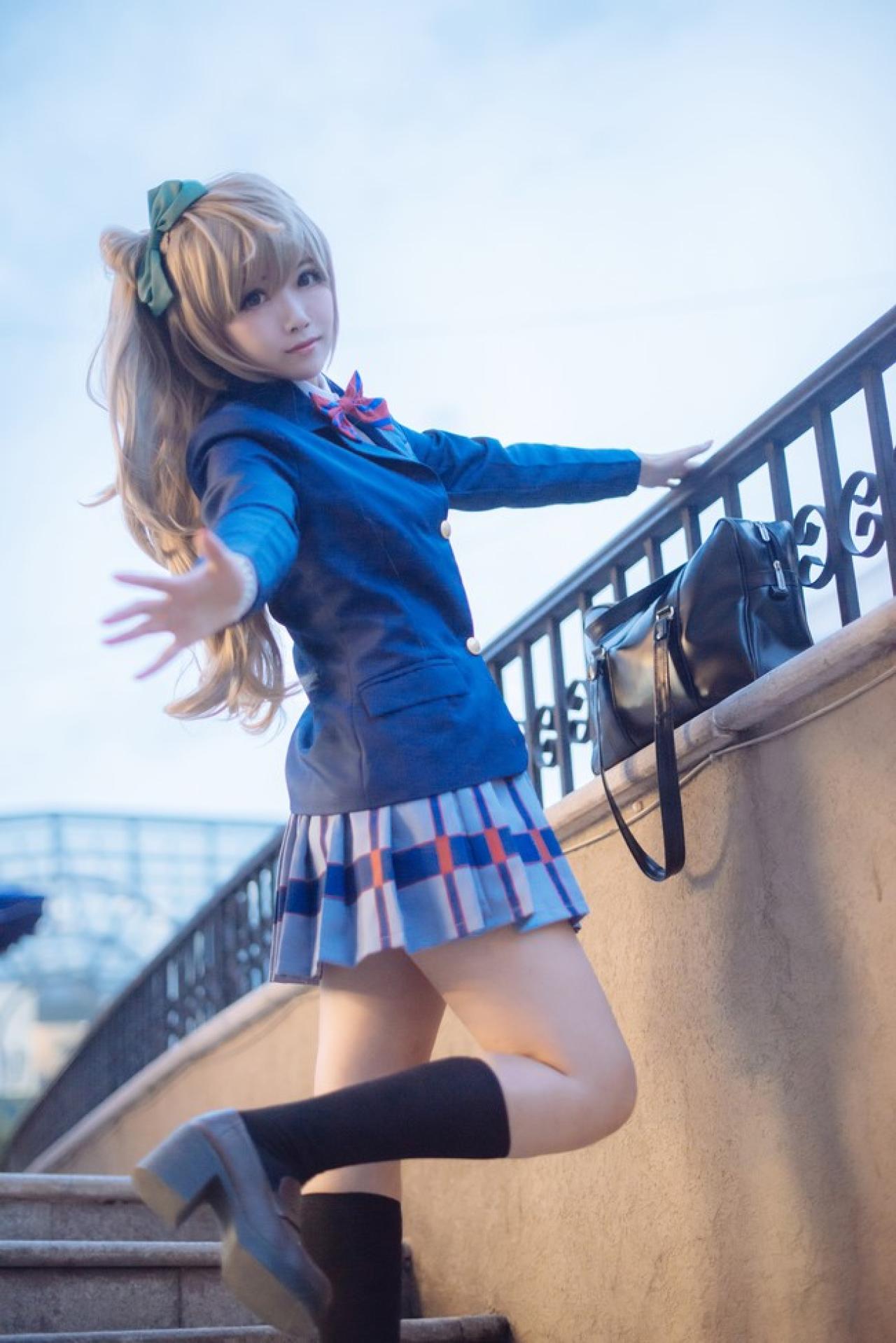 四月www扮演南小鸟在栏杆旁，胳臂伸展，飞翔的姿势