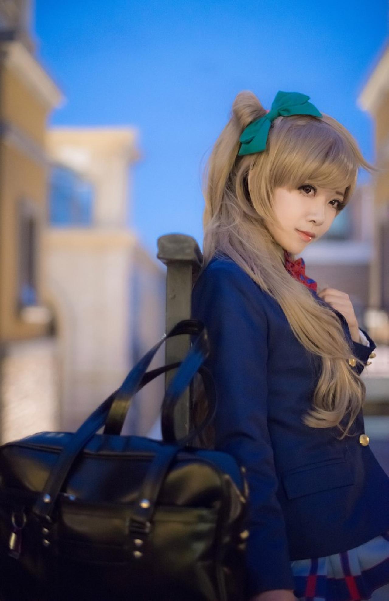 四月www扮演南小鸟把挂包放在台子上，靠在栏杆，右手下垂，左手放在胸前静静思考的侧面