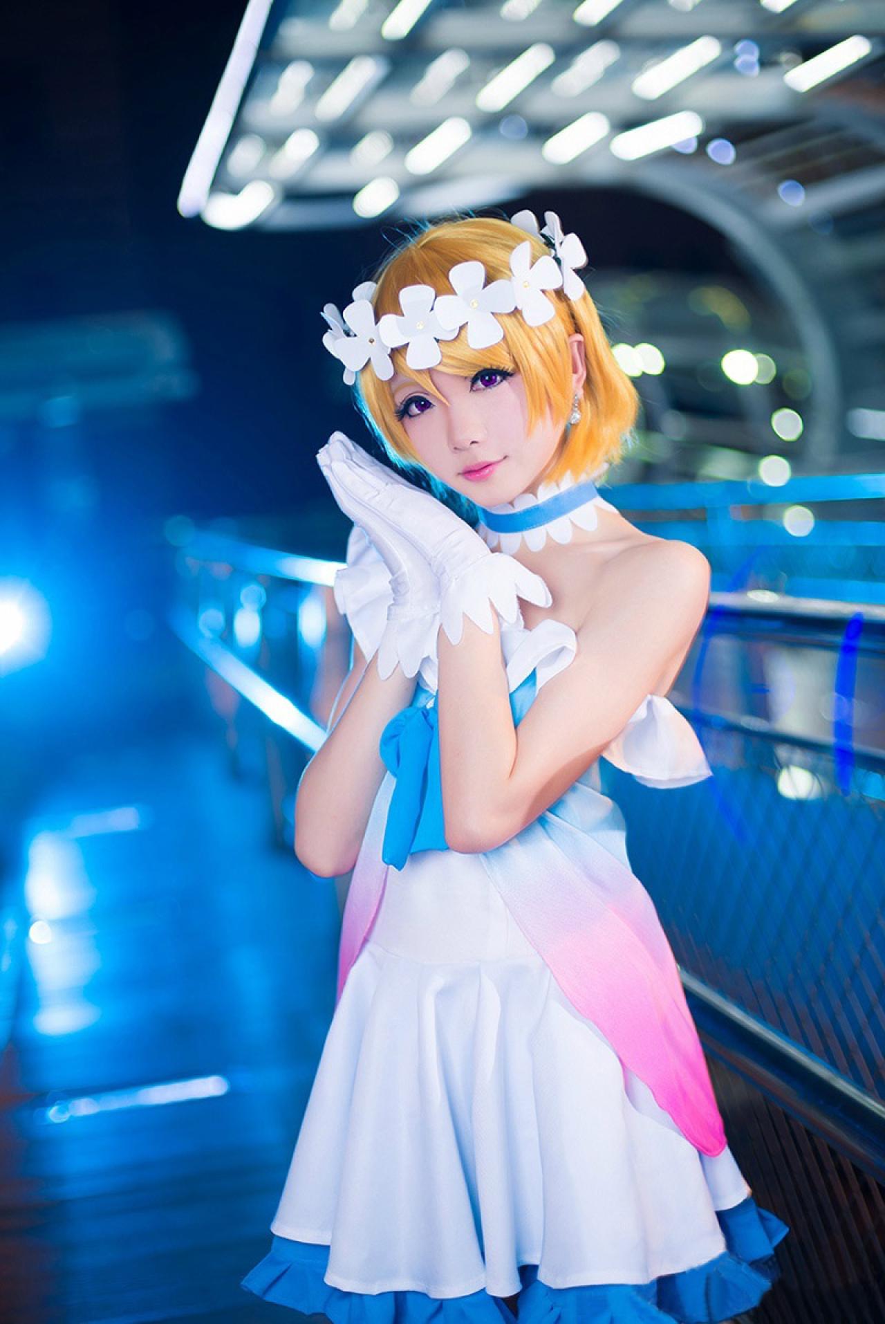 Hoshilily穿着蓝纱渐变打歌服扮演小泉花阳，双手合十，枕在耳边