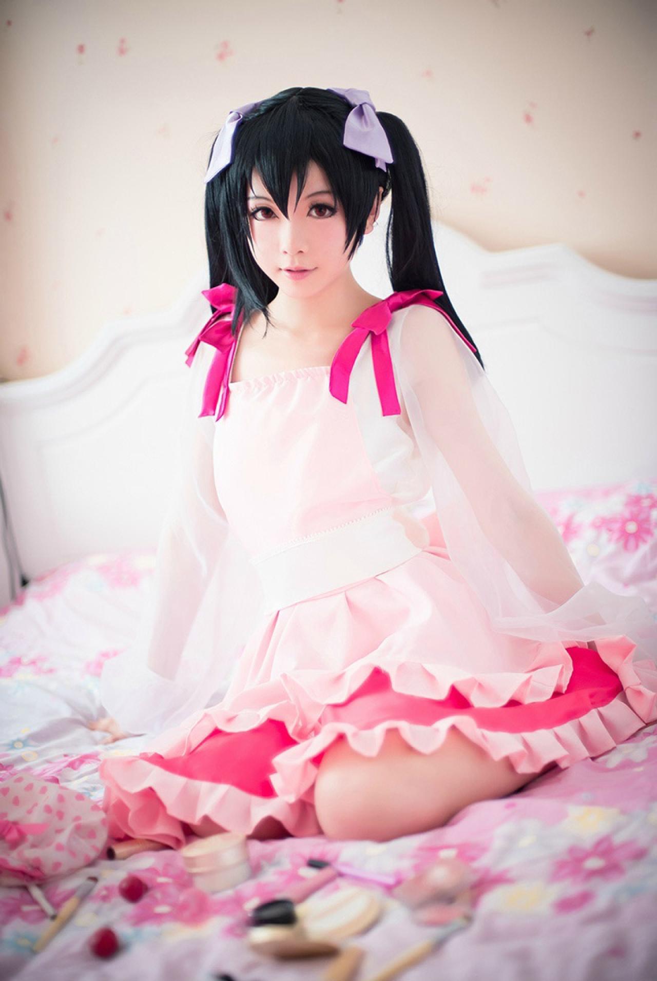 Hoshilily扮演矢泽妮可端坐在床上，身旁是一个打开的袋子，各种化妆品自然散落在床单上