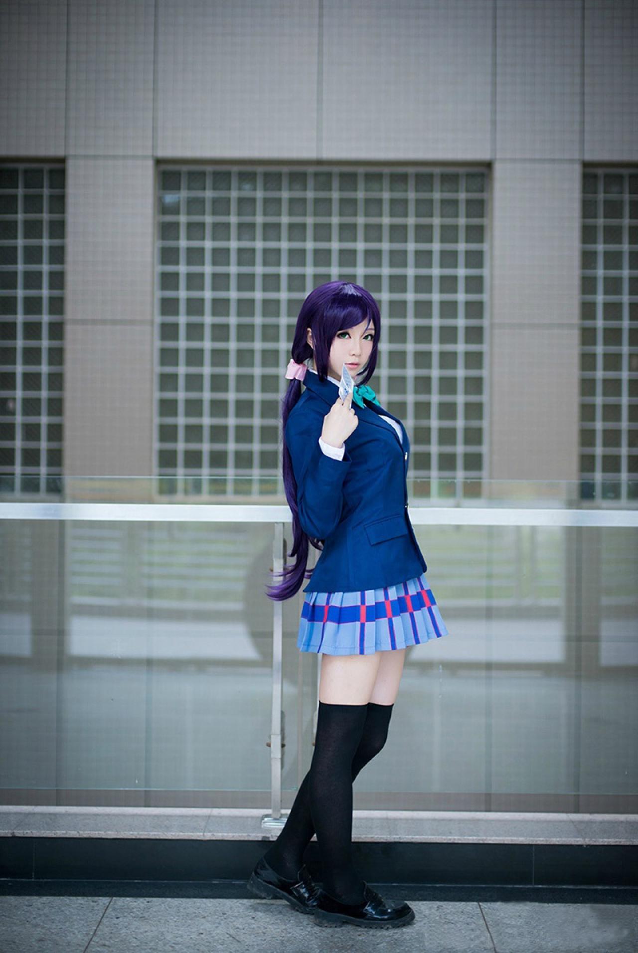 Hoshilily扮演东条希拿着卡牌漫步在学校的外走廊上，这是一张侧面照