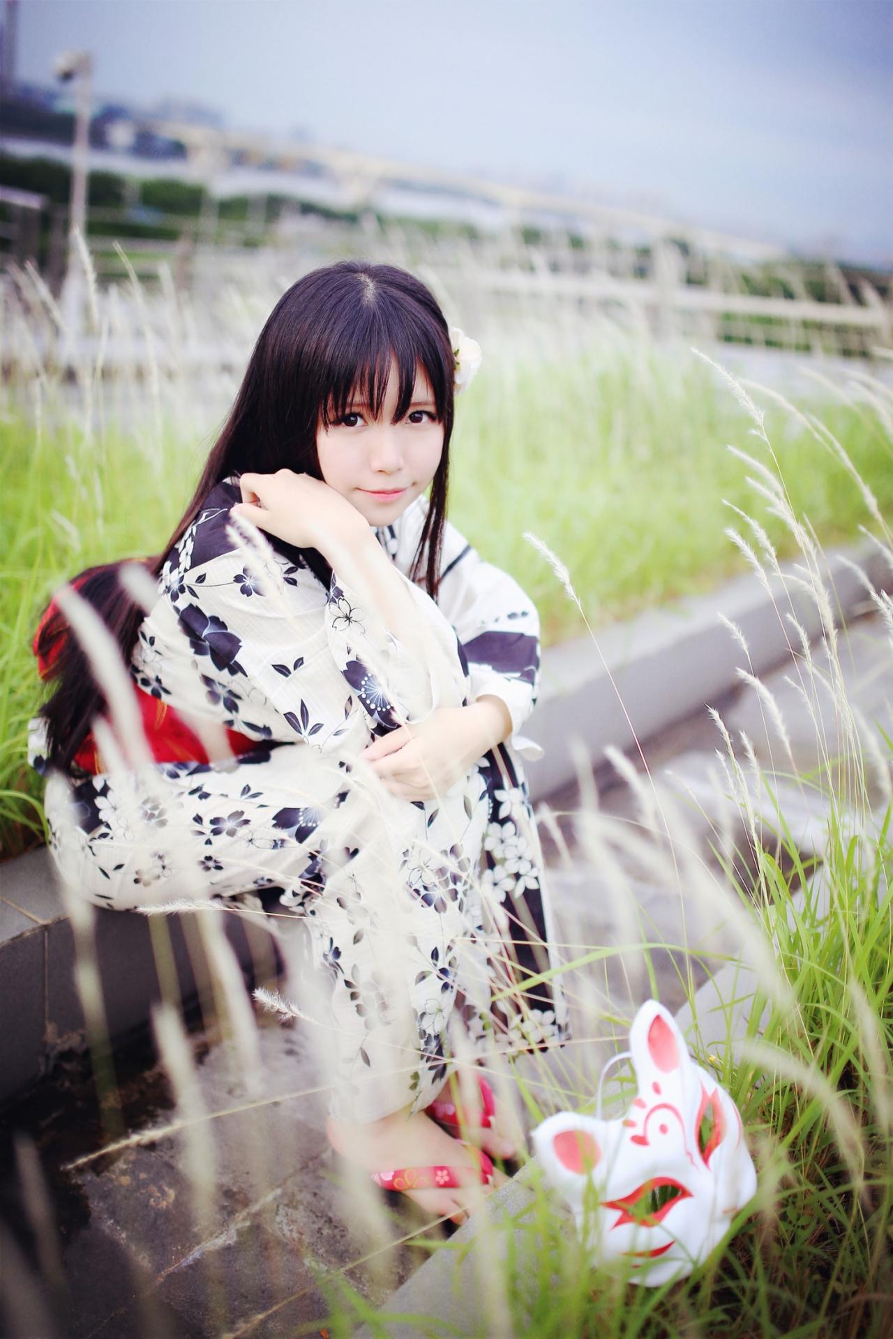 安姐姐坐在草池旁边，微笑地看着镜头