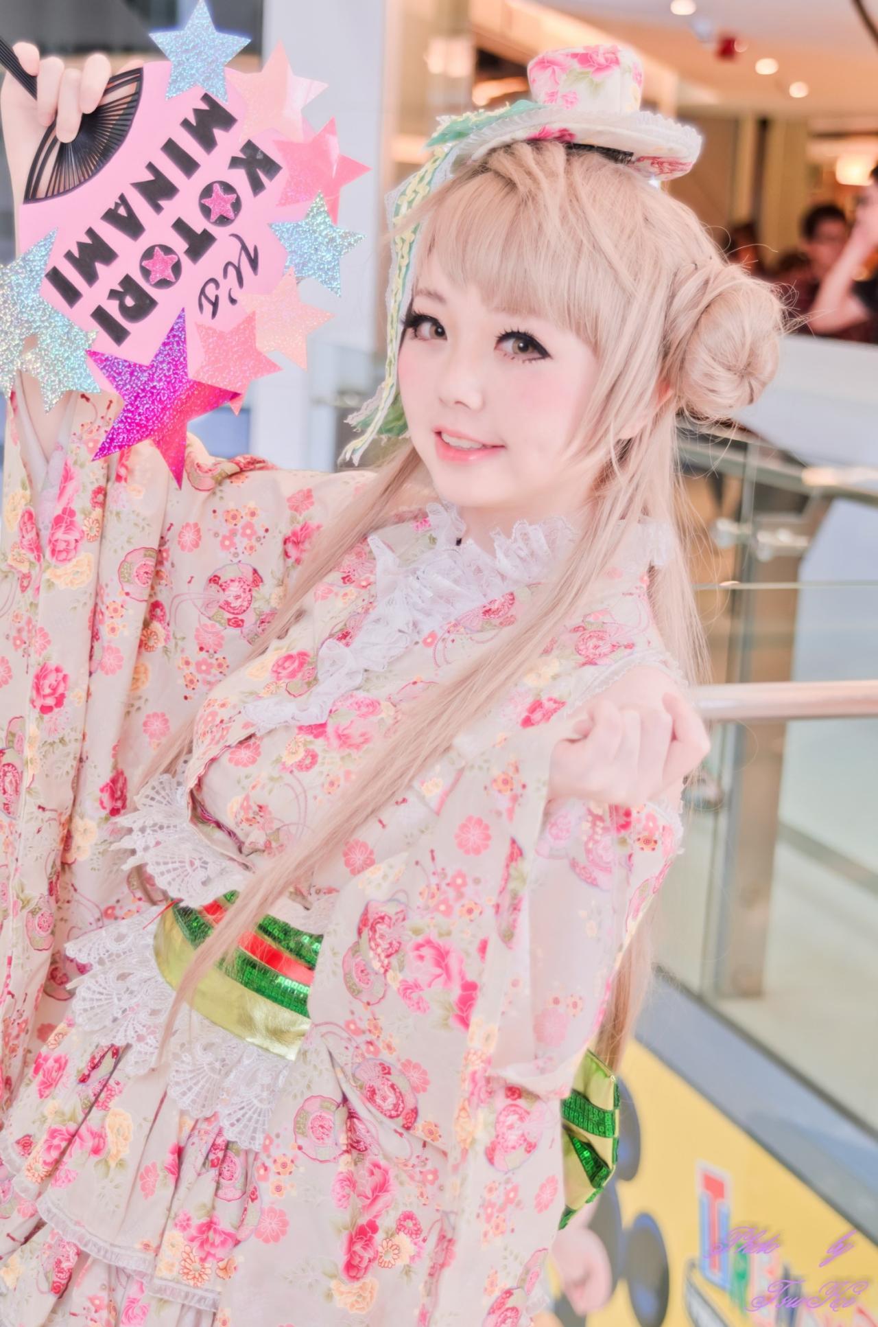 Hikari扮演南小鸟左手半握拳举起，右手举起扇子的姿势