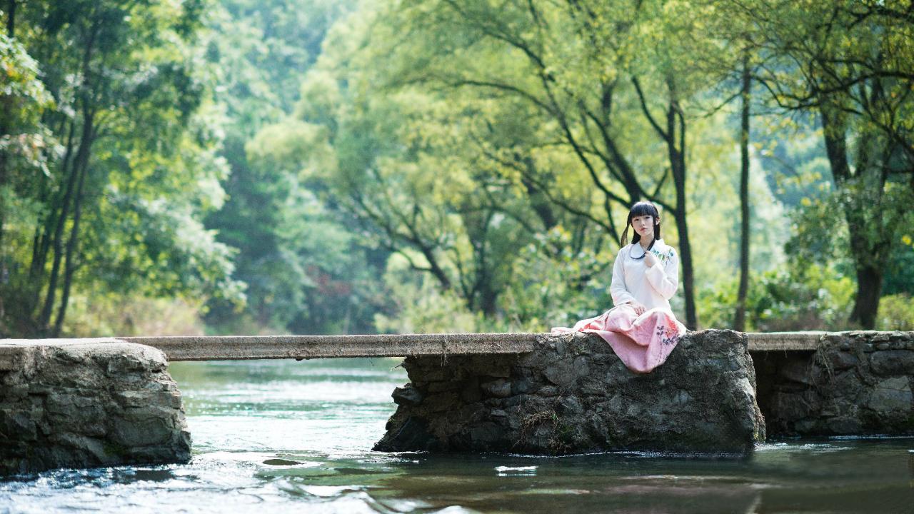 猫小音端坐在石桥水边