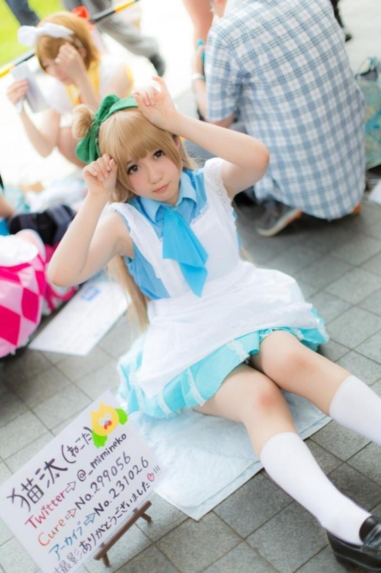 橘猫汰扮演南小鸟头顶小猫手势，旁边的白色牌子上有猫汰的联系方式哦！